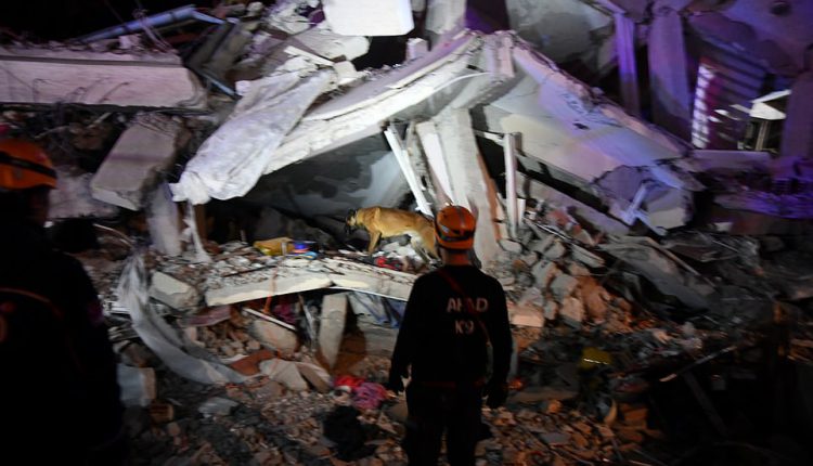 23845726-7926331-A_rescuer_stands_in_front_of_a_collapsed_building_today_after_ea-a-6_1579918046212